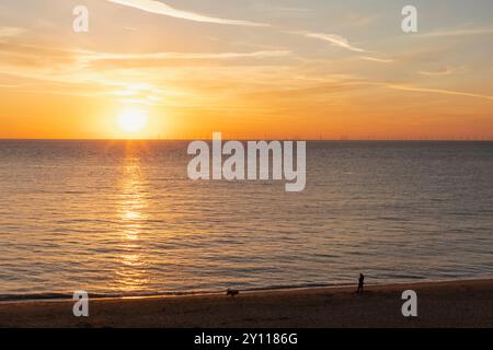 England, Kent, Kingsgate Bay, man and Dog on Beach at Sunrise Stockfoto