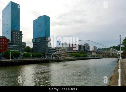 Die Zwillingstürme des Isozaki-Torkomplexes und die Fußgängerbrücke des Zubizuri-Bogens über den Fluss Nerbiol Bilbao Baskenland Euskadi Spanien Stockfoto