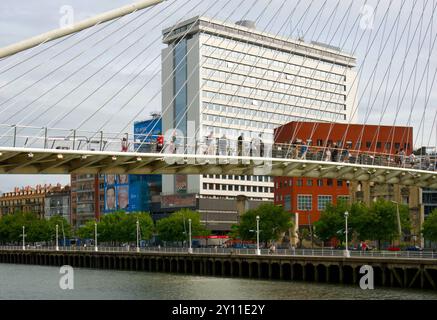 Die Menschen überqueren die weiße Fußgängerbrücke Campo Volantin über den Fluss Nervion im Stadtzentrum von Bilbao Baskenland Euskadi Spanien Stockfoto