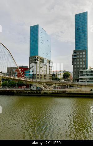 Die Zwillingstürme des Isozaki-Torkomplexes und die Fußgängerbrücke des Zubizuri-Bogens über den Fluss Nerbiol Bilbao Baskenland Euskadi Spanien Stockfoto