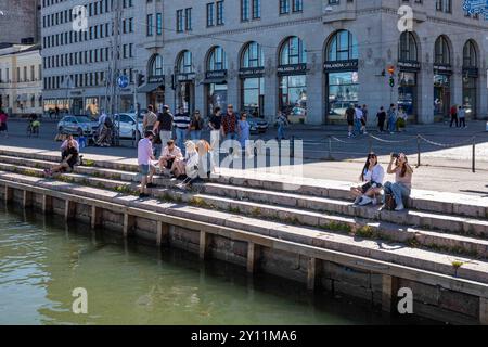 Menschen genießen die Nachmittagssonne am Ufer von Kolera-allas in Helsinki, Finnland Stockfoto