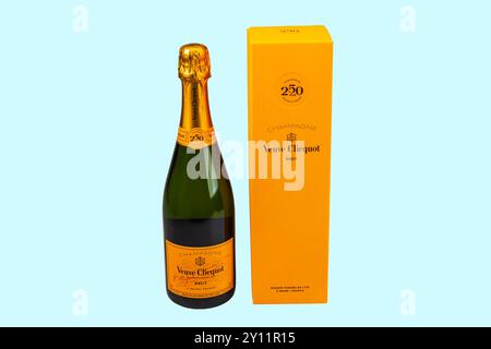 Nahansicht der Veuve Clicquot Champagnerflasche mit Box isoliert auf blauem Hintergrund. Stockfoto