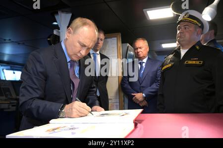Wladiwostok, Russland. September 2024. Der russische Präsident Wladimir Putin, links, unterschreibt das Gästebuch an Bord der russischen Marine Stereguschchij-Klasse-Lenkraketenkorvette Rezky mit Schiffskommandant Jewgeni Kovalew, rechts, bei der Primorje Flottille der Allwaffen-Streitkräfte, 4. September 2024 in der Uliss-Bucht, Wladiwostok, Russland. Quelle: Vyacheslav Prokofyev/Kreml Pool/Alamy Live News Stockfoto