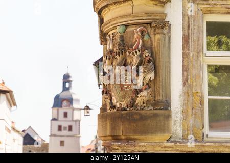 Zarte und farbenfrohe Reliefs zieren die Ecke eines historischen Gebäudes in Waltershausen, die Handwerkskunst aus vergangener Zeit gegen ein klares B hervorheben Stockfoto