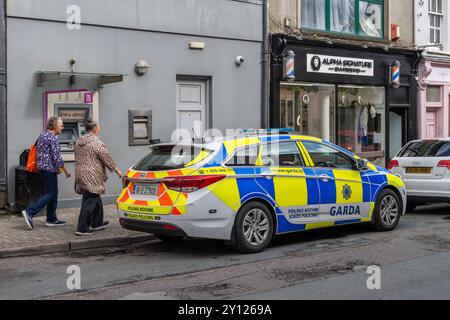 Zwei ältere Frauen laufen an einem Garda-Streifenwagen vorbei, der in Bandon, West Cork, Irland, geparkt ist. Stockfoto