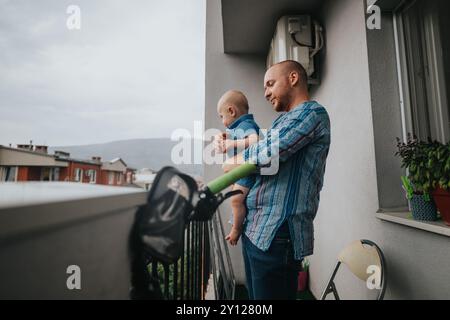 Vater und Baby genießen einen ruhigen Moment auf dem Balkon Stockfoto