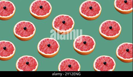 Lebensmittelmuster. Grapefruits. Zitrusfrüchte. Vitamine. Eine halbe Grapefruit mit schwarzer Johannisbeere drauf. Konzept für gesunde Ernährung. Künstlerische Hintergründe Stockfoto