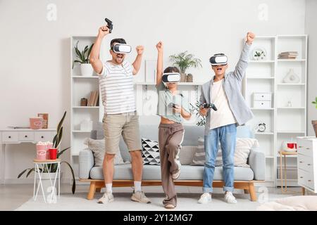 Glücklicher Vater mit seinen Kindern in einer VR-Brille, die zu Hause Videospiele spielt Stockfoto