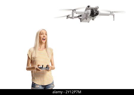 Eine junge Frau, die eine Drohne auf weißem Hintergrund fliegt Stockfoto