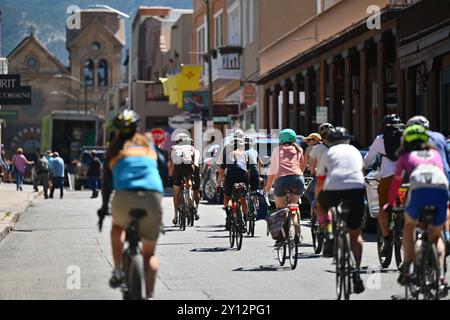 Lael Wilcox, Zentrum, wird von mehreren Radfahrern begleitet, als sie am 4. September 2024 in Santa Fe, New Mexico, durch den Santa Fe Plaza fährt. Wilcox versucht, den Rekord für die schnellste Weltumrundung mit einem Fahrrad einer Frau zu brechen, die derzeit von Jenny Graham gehalten wird, in einer Zeit von 124 Tagen und 11 Stunden. Laut Guinness-Weltrekorden muss ein Fahrer die gleiche Distanz wie der Erdumfang - 24.900 Meilen - in eine Richtung zurücklegen, wobei er an derselben Stelle beginnt und endet. Das Reisen auf dem See- und Luftweg ist erlaubt, aber mindestens 18.000 Meilen der Route müssen mit dem Fahrrad gefahren werden. (Pho Stockfoto