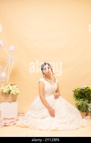 Elegante Frau posiert sitzend formell entspannt fröhlich blickend nach vorne ihre Treppe lehnend aneinander in schönen Kleidern Indoor Foto-Portra Stockfoto