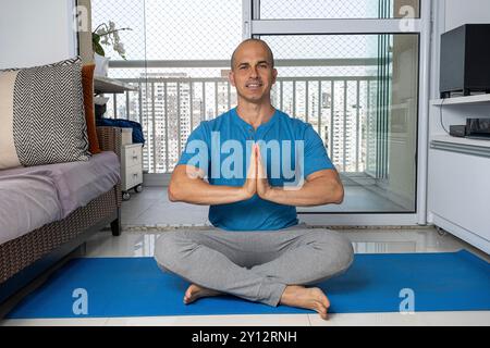 48-jähriger brasilianischer Mann, der zu Hause Yoga praktiziert 1. Stockfoto