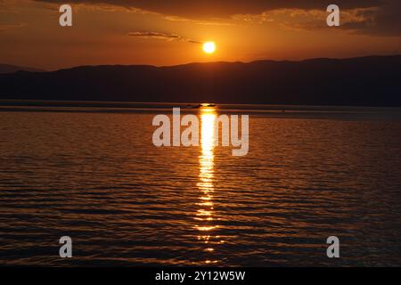 Orange Sonnenuntergang über den Bergen Albaniens über dem See Ohrid von Nordmazedonien Stockfoto