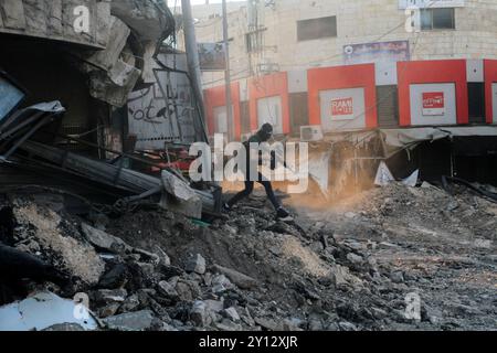 Jenin, Palästina. September 2024. Ein maskierter palästinensischer bewaffneter stößt mit israelischen Truppen zusammen, die in das Zentrum des Lagers Dschenin nördlich der besetzten Westbank vorrücken, nachdem ein Angriff auf die Stadt ihren siebten Tag eintrat. Quelle: SOPA Images Limited/Alamy Live News Stockfoto