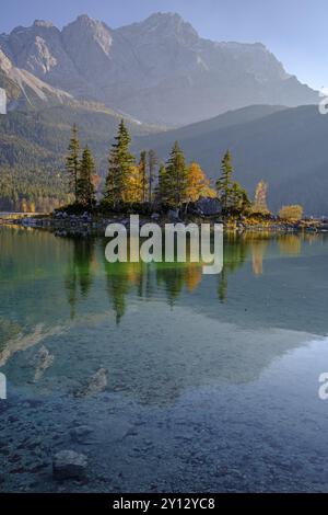 Spiegelbild einer Insel in einem Bergsee vor steilen Bergen, Herbst, Abendlicht, Eibsee, Zugspitze, Bayern, Deutschland, Europa Stockfoto