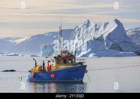 Fischerboot vor Eisbergen, Fjord, Sommer, sonnig, Uummannaq, Westgrönland, Grönland, Nordamerika Stockfoto