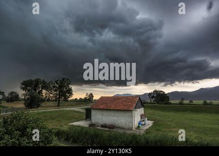 Dunkle Sturmwolken über einer kleinen Scheune, windig, Schlehdorf, Bayern, Deutschland, Europa Stockfoto