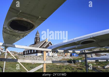 Traditionelle Kajaks auf einem Holzrahmen vor einer Kirche, Sommer, Inuit, Zion's Church, Ilulissat, Ilulissat Icefjord, Disko Bay, Westgrönland, Gre Stockfoto