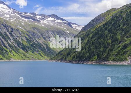 Ein friedlicher Bergsee umgeben von grünen Bergen, schneebedeckten Gipfeln und klarem blauem Himmel, Mayrhofen, Zillertal, Österreich, Europa Stockfoto