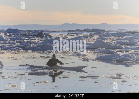 Inuit paddelt ein Kajak zwischen Eisbergen, Mann, Sonne, Sommer, Ilulissat, Ilulissat Icefjord, Disko Bay, Westgrönland, Grönland, Nordamerika Stockfoto