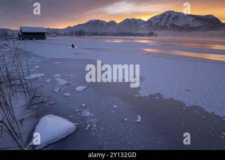 Berge spiegeln sich in See, Sonnenaufgang, Nebel, Winter, Schnee, Ice, Kochelsee, Alpenvorland, Bayern, Deutschland, Europa Stockfoto