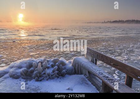 Eisbedecktes Ufer eines Sees bei Sonnenaufgang, Bank, Winter, Starnberger See, Vorgebirge, Oberbayern, Bayern, Deutschland, Europa Stockfoto