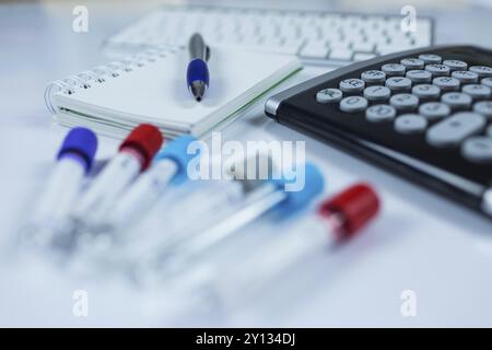 Nahaufnahme Foto von Medizin Flaschen für Proben neben Computer Tablet und Computer Tastatur im Krankenhaus oder Labor Stockfoto