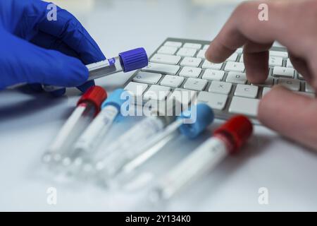 Nahaufnahme Foto von Medizin Flaschen für Proben neben Computer Tablet und Computer Tastatur im Krankenhaus oder Labor Stockfoto