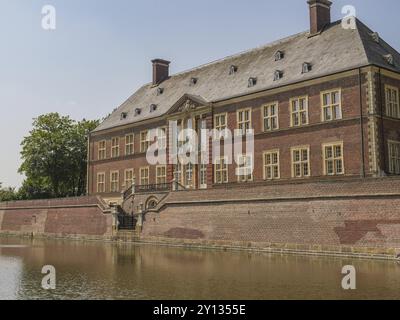 Ein beeindruckendes historisches Backsteinschloss mit vielen Fenstern, neben einem Graben, der eine faszinierende und majestätische Atmosphäre vermittelt, ahaus, münsterland, germa Stockfoto