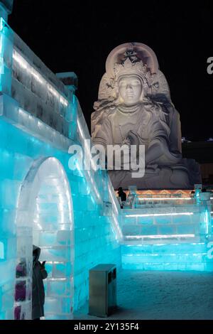 1. Januar 2022, HARBIN, CHINA. Vertikales Bild spektakulärer beleuchteter weißer Eisskulpturen in Harbin, China. Nachtbild mit Kopierraum für Tex Stockfoto