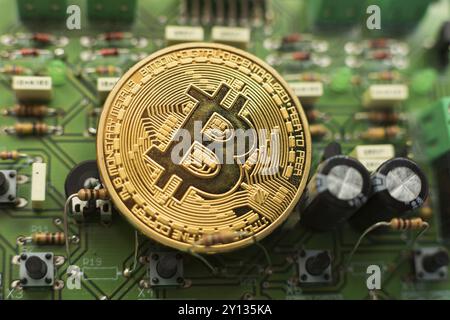 Bitcoin-Goldmünze auf Computerplatinen-Mikrochips. Elektronische Kryptowährung Stockfoto