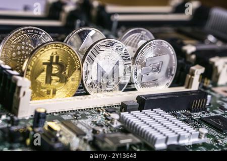 Golden Bitcoin und Altcoins Monero und DASH Cryptocurrency auf der Computerplatine. Blockchain- und Sicherheitskonzept Stockfoto