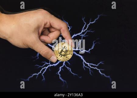 Mann hält Bitcoin gold Münze vor Blitzschlag netzwerk konzept Hintergrund Stockfoto