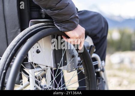 Junge behinderte Menschen im Rollstuhl in der freien Natur beobachten, Berge und Natur Stockfoto