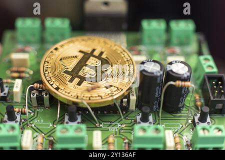 Bitcoin-Goldmünze auf Computerplatinen-Mikrochips. Elektronische Kryptowährung Stockfoto