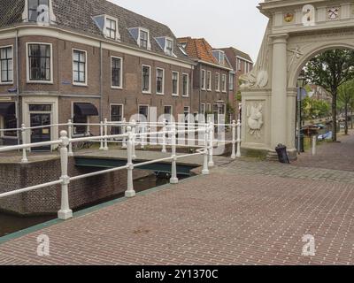 Eine malerische Brücke und historische Gebäude entlang eines Kopfsteinpflasterpfads und Kanals, Leiden, Niederlande Stockfoto