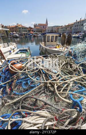 Malerischer Hafen mit Booten und farbenfrohen Häusern am Fischernetz in Izola, Isola Stockfoto