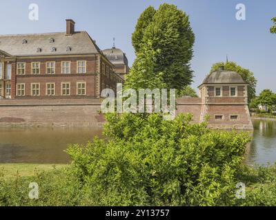 Ein historisches Backsteinschloss, umgeben von einem Graben und Bäumen, das eine ruhige und verzauberte Atmosphäre ausstrahlt, ahaus, münsterland, deutschland Stockfoto