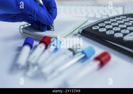 Nahaufnahme Foto von Medizin Flaschen für Proben neben Computer Tablet und Computer Tastatur im Krankenhaus oder Labor Stockfoto