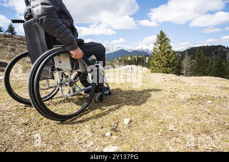 Junge behinderte Menschen im Rollstuhl in der freien Natur beobachten, Berge und Natur Stockfoto