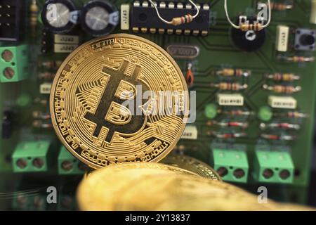 Bitcoin-Goldmünze auf Computerplatinen-Mikrochips. Elektronische Kryptowährung Stockfoto