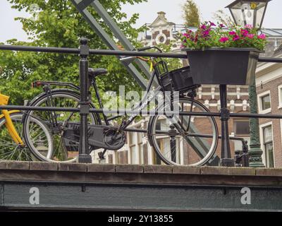 Fahrrad auf einer Brücke in einer historischen Stadt, dekoriert mit einem Blumenkasten, Leiden, Niederlande Stockfoto