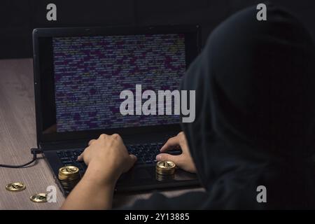 Gefährliche hooded Hacker auf Laptop bricht Computer Security sistem und stehlen Bitcoin cryptocurrency Stockfoto