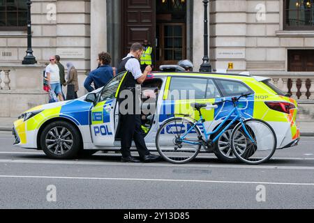 Ein Polizist bewegt ein Fahrrad nach einem bösen Unfall mit einem Radfahrer und einem vorbeifahrenden LKW auf dem Parlamentsplatz. Stockfoto