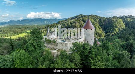 Panoramablick auf die Burg Zovnek, die älteste mittelalterliche Festung Sloweniens mit teilweise restauriertem großen Turm, Burgtor und Zugbrücke Stockfoto
