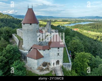 Panoramablick auf die Burg Zovnek, die älteste mittelalterliche Festung Sloweniens mit teilweise restauriertem großen Turm, Burgtor und Zugbrücke Stockfoto