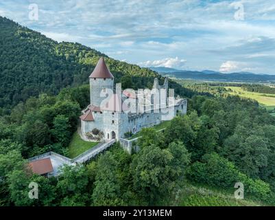 Panoramablick auf die Burg Zovnek, die älteste mittelalterliche Festung Sloweniens mit teilweise restauriertem großen Turm, Burgtor und Zugbrücke Stockfoto
