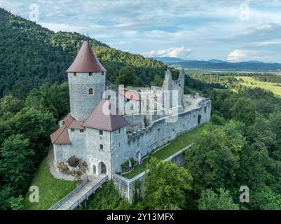 Panoramablick auf die Burg Zovnek, die älteste mittelalterliche Festung Sloweniens mit teilweise restauriertem großen Turm, Burgtor und Zugbrücke Stockfoto