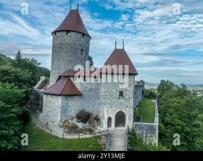 Panoramablick auf die Burg Zovnek, die älteste mittelalterliche Festung Sloweniens mit teilweise restauriertem großen Turm, Burgtor und Zugbrücke Stockfoto