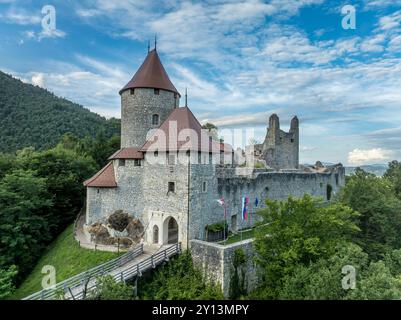 Panoramablick auf die Burg Zovnek, die älteste mittelalterliche Festung Sloweniens mit teilweise restauriertem großen Turm, Burgtor und Zugbrücke Stockfoto